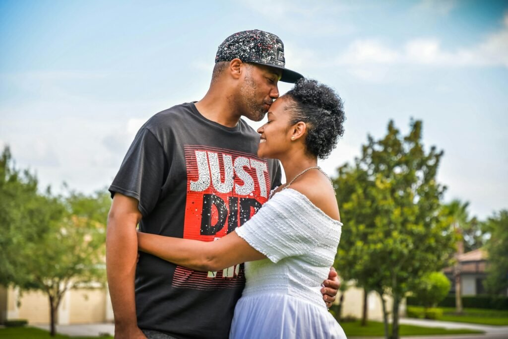 man in black crew neck t-shirt kissing woman in white dress - black love